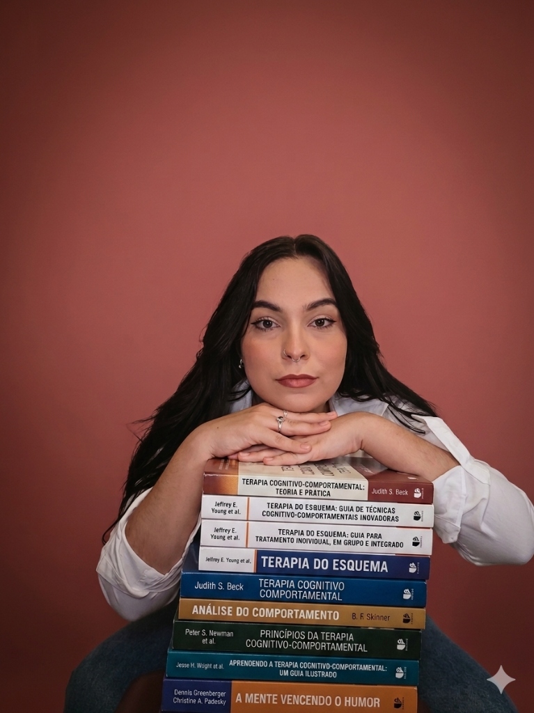 Foto de Elen Garcia com a cabeça apoiada em uma pilha de livros de psicologia